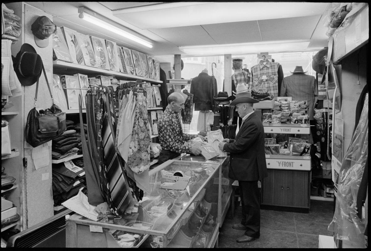 Interior view of 'Maurice Merchant Navy General Outfitter', 5 James Street, Butetown, showing the proprietor Mr M. Colpstein serving merchant seaman Mr T. Szarota. This was the last remaining outfitters in Cardiff Dockland.