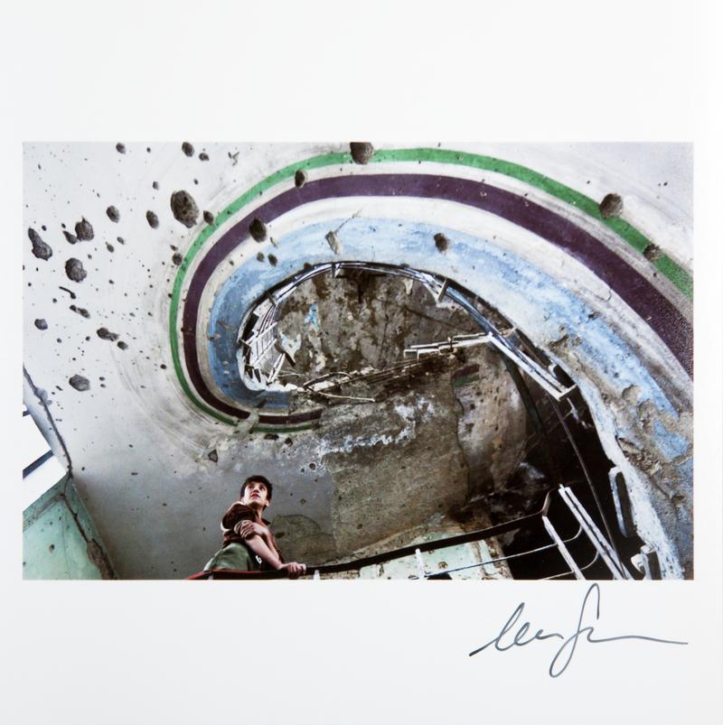 A displaced young man stands on the staircase of the old Kabul Cinema, a building destroyed during the Afghan Civil War of the 1990's