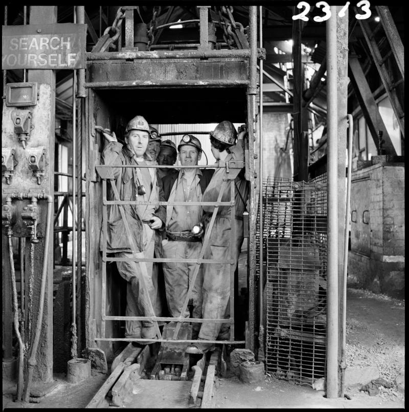 Black and white film negative showing miners in the cage at pit top, Morlais Colliery 13 May 1981.  'Morlais 13/5/81' is transcribed from original negative bag.