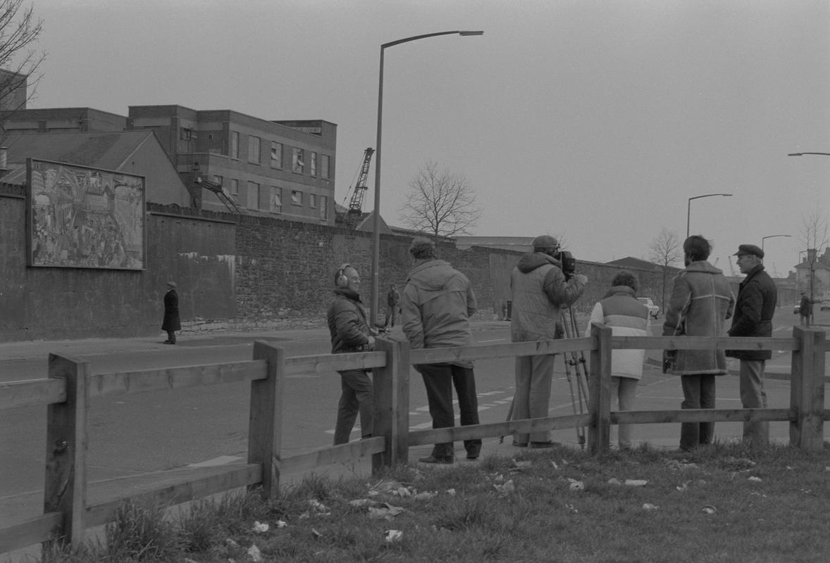 Film crew on Bute Street opposite mural on wall of railway embankment.