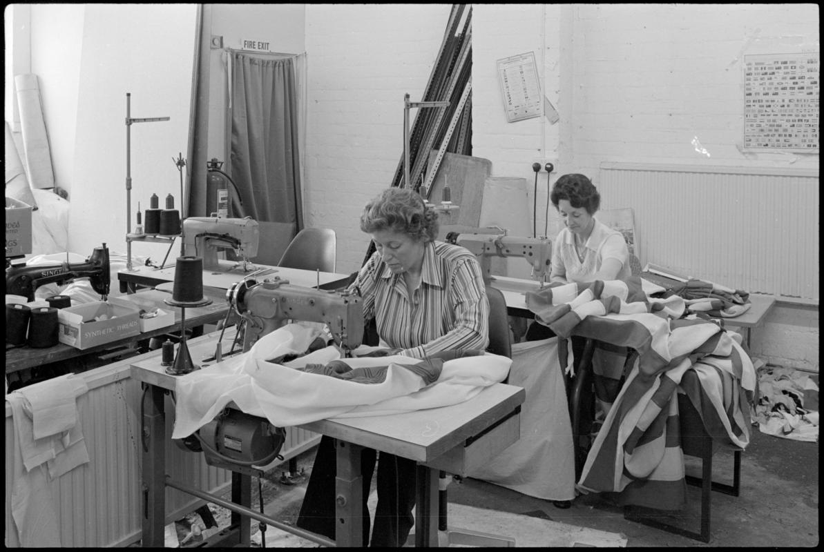 Interior view of J.G Eveleigh and Company flagmakers workshop at Hunter Street, Cardiff Docks showing Mrs Jean Eveleigh and assistant using sewing machines.