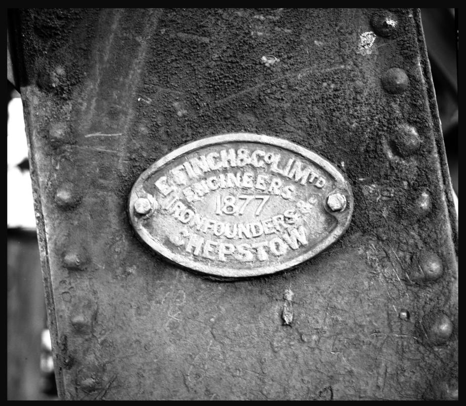 Black and white film negative showing a maker's plate on ironwork engraved with 'E. Finch & Co Ltd Engineers, 1877, Ironfounders, Chepstow'.