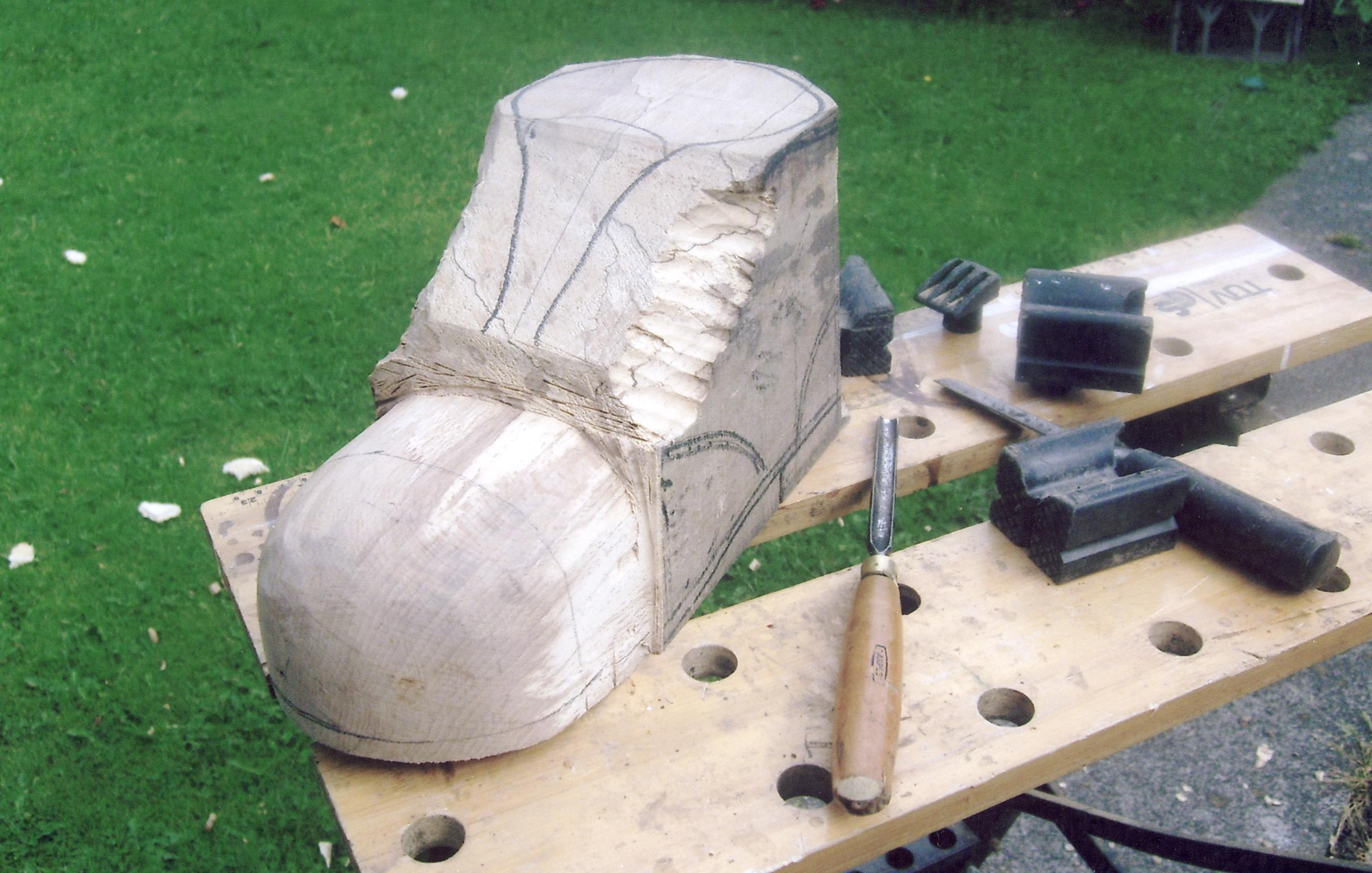 Stages in manuf. of carved wooden boot, photograph