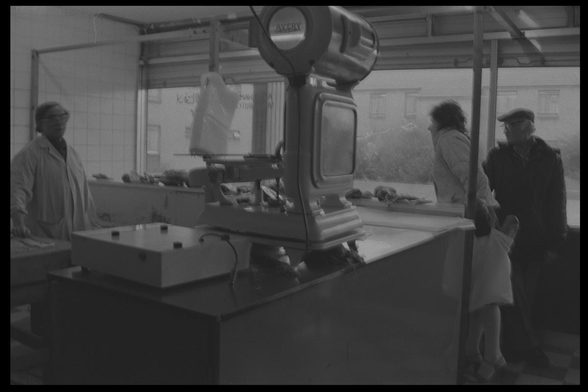 Customers in butcher shop, Loudoun Square, Butetown.