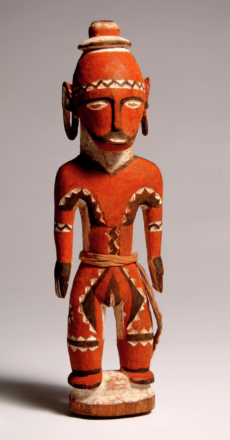 Aboriginal doll, possibly of totemic significance and possibly of South Pacific origins; carved into human form from one piece of wood; painted red, with black and white painted patterns.