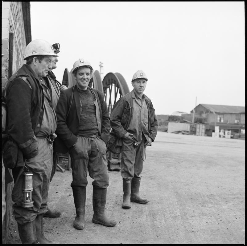 Black and white film negative showing four miners on the surface, Tower Colliery.  'Tower' is transcribed from original negative bag.