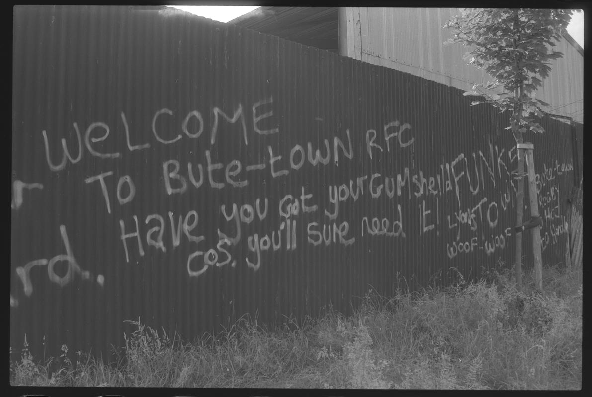 Graffitti on corrugated iron fence in Butetown.