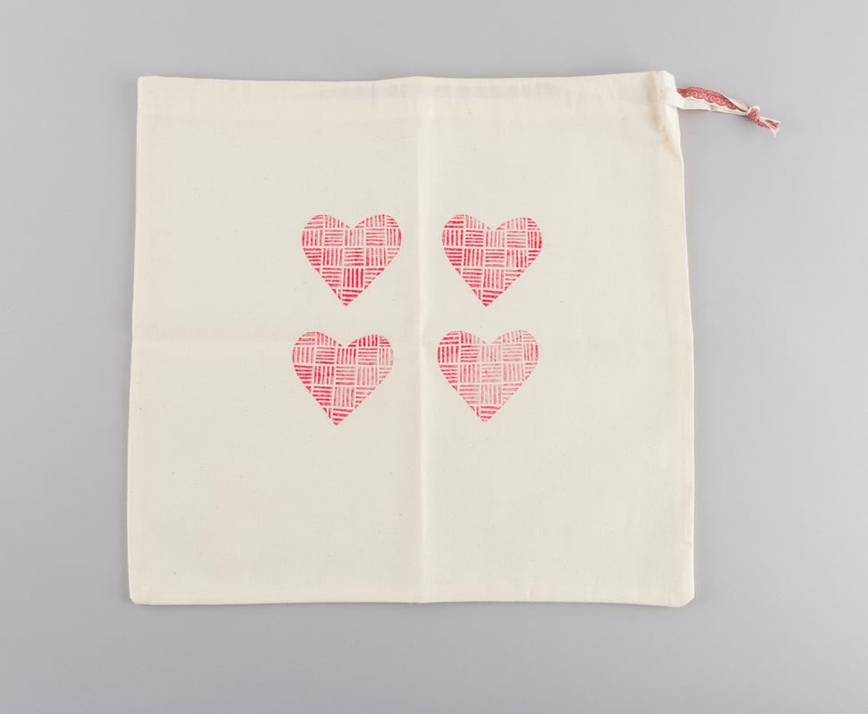 Scrub bag with four hearts printed on the front.