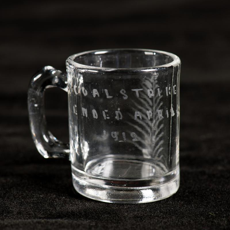 Glass cup engraved COAL STRIKE / ENDED APRIL 6 / 1912 on one side and fern leaf on the other