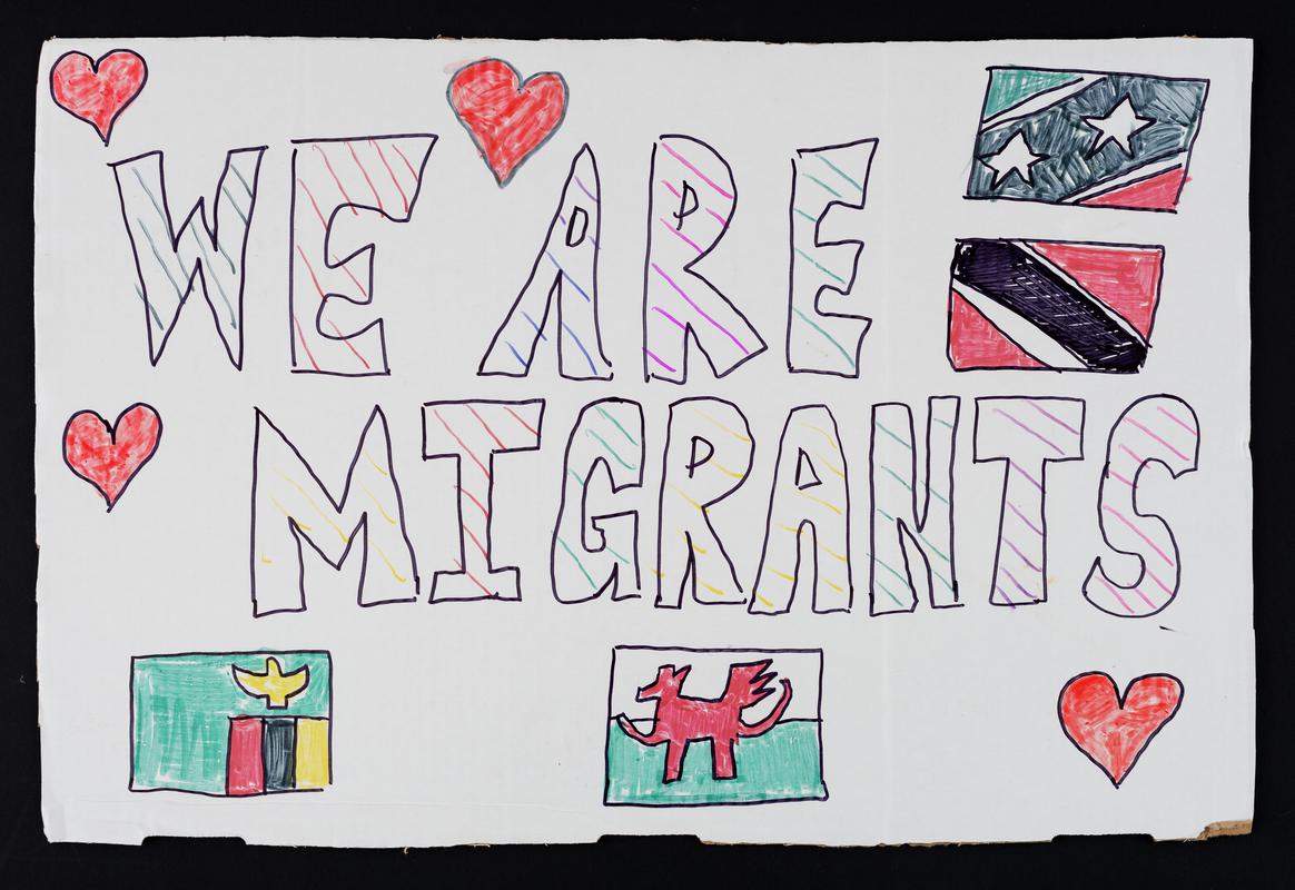 'We Are Migrants' placard used at the One Day Without Us migrants rally outside the Senedd on 17 February 2018.