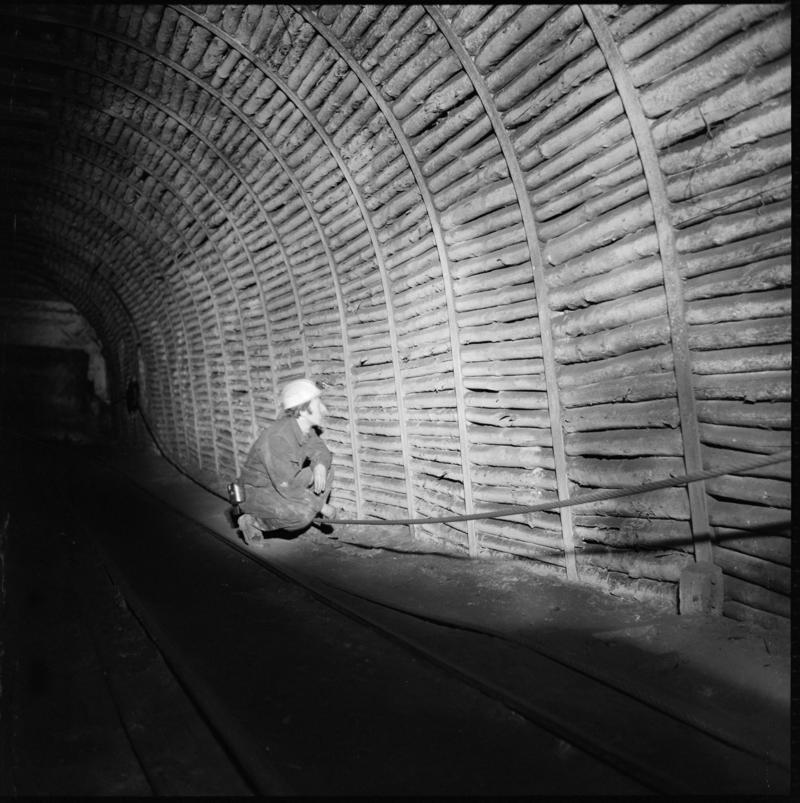 Black and white film negative a man underground, Tymawr Colliery 21 December 1976.  'Ty Mawr 21/Dec/76' is transcribed from original negative bag.