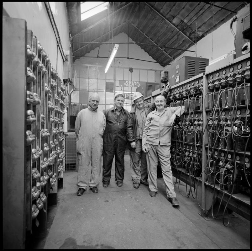 Black and white film negative showing four men in the lamproom, Coegnant Colliery, 25 November 1981.  '25 Nov 1981' is transcribed from original negative bag.