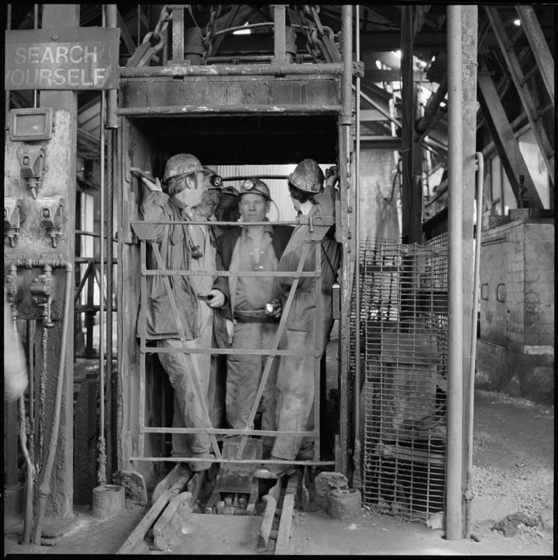 Black and white film negative showing men in the cage at pit top, Morlais Colliery 13 May 1981.  'Morlais 13/5/81' is transcribed from original negative bag.