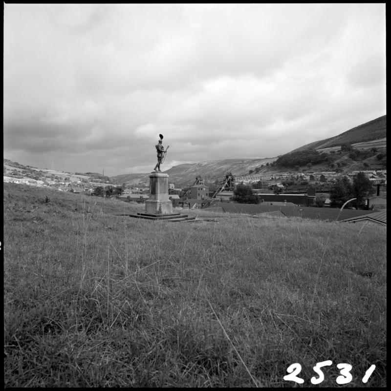 Black and white film negative showing a memorial statue with Merthyr Vale Colliery in the background, 21 September 1981.  'Merthyr Vale 21 Sep 1981' is transcribed from original negative bag.