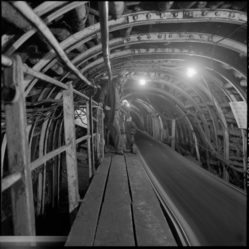 Black and white film negative showing men beside a conveyor, Celynen North Colliery 1978-9.  'Celynen North 1978-9' is transcribed from original negative bag.