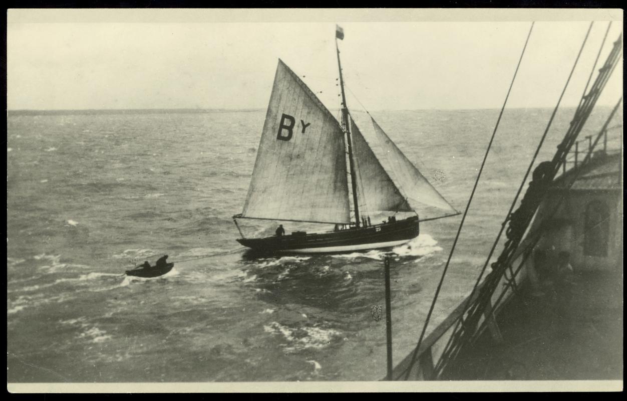 View of the Bristol Channel pilot cutter KINDLY LIGHT putting pilot L. Alexander on board a steamer off Linney Head, Pembroke