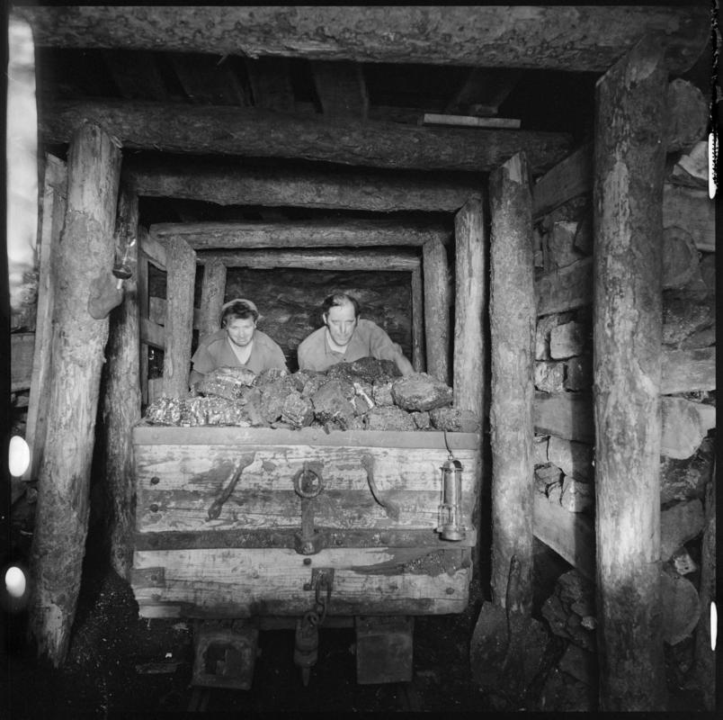 Black and white film negative showing two men at one of the coal faces where visitors to the museum can see a recreation of the working conditions underground, Big Pit Mining Museum.