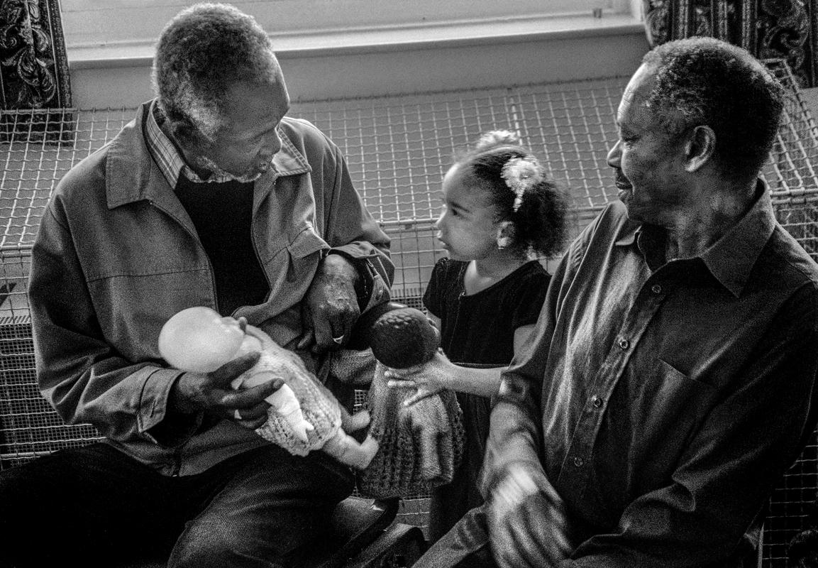 GB. WALES. Cardiff. Butetown - once know as 'Tiger Bay'. Carl Alexis and granddaughter in St Paul's, Loudoun Square. 2003.