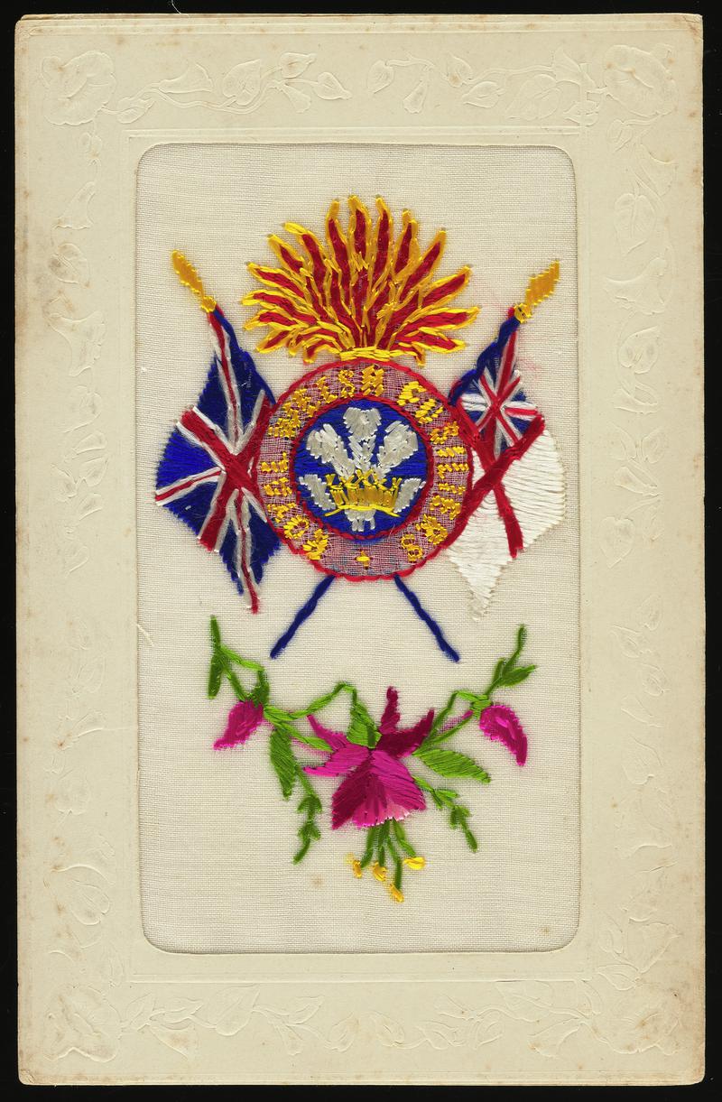 Embroidered silk postcard. Sent from France possibly by Gordon Hobbs or Tom Hardiman. Undated. Embroidered with Royal Welsh Fusiliers symbols and floral spray of red fuschias. No message on back.