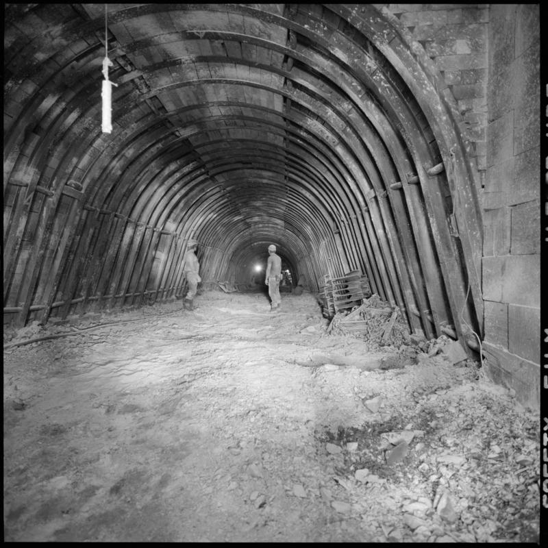 Black and white film negative showing two men stood in an underground roadway, Merthyr Vale Colliery 2 July 1981.  '2 Jul 1981' is transcribed from original negative bag.