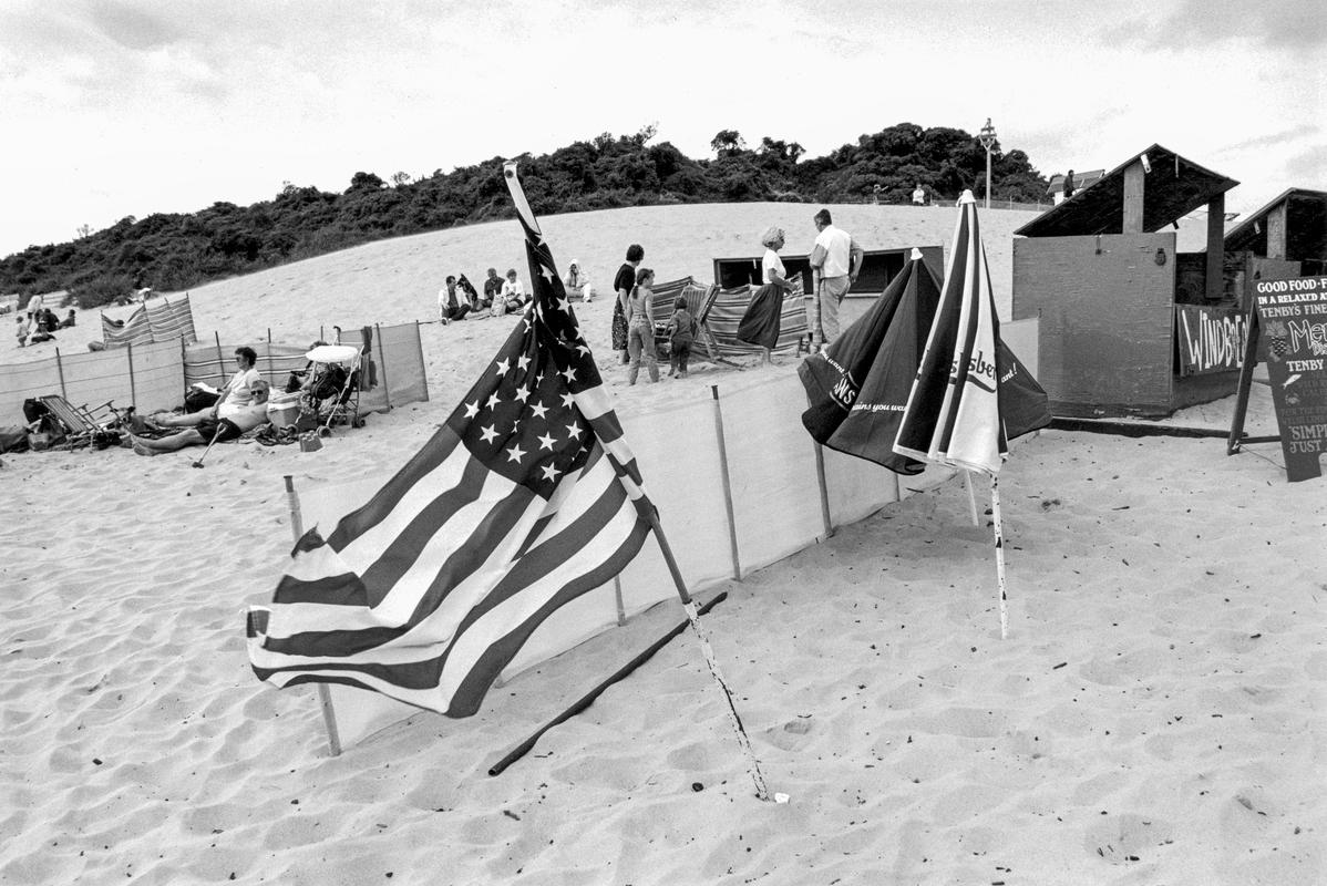 GB. WALES. Tenby. American flag on the beach. At a beach food stall. 1995