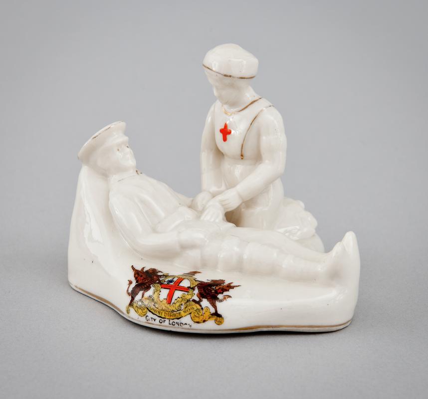Figurine of a Red Cross nurse giving medical assistance to a wounded soldier