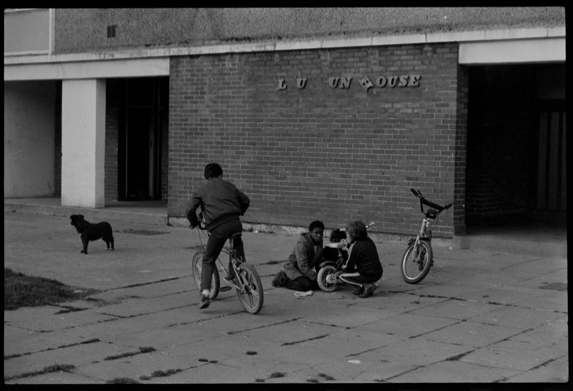 Children playing on bikes outside flats, Butetown.