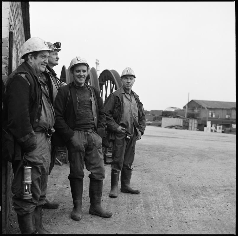 Black and white film negative showing four miners on the surface, Tower Colliery.  'Tower' is transcribed from original negative bag.