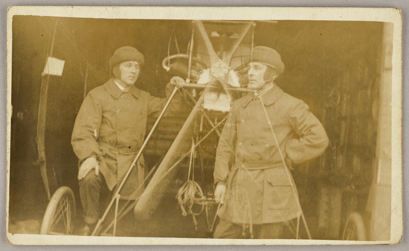 Photograph of Watkins monoplane with two men in flying gear (one presumably C.H. Watkins). ?Is it a double exposed print?
