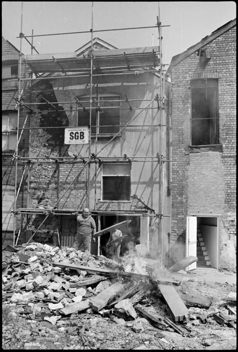 Workmen burning old timber outside 105 and 106 Bute Street, Butetown. These premises were being renovated by Graham Bros. builders.