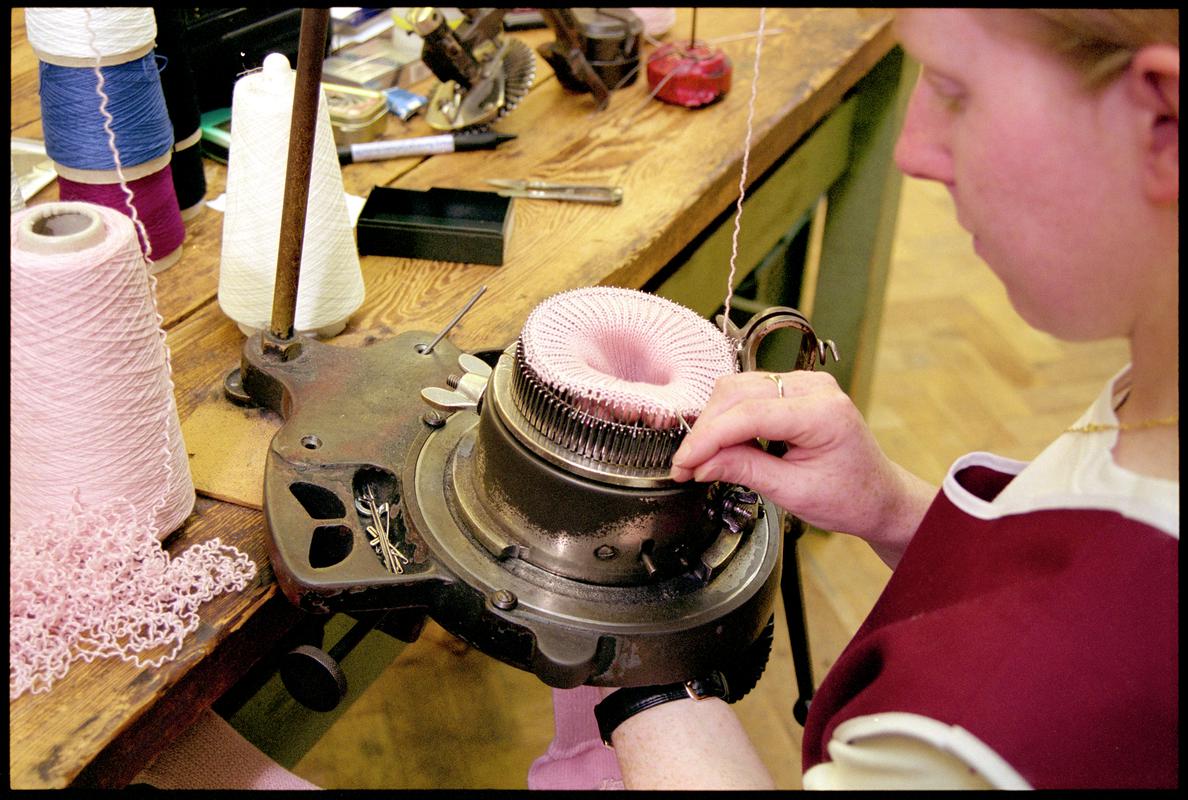 Andrea Rockman attaching sock welt to a knitting machine. Corgi Hosiery Ltd factory, Ammanford, 1 July 2002.