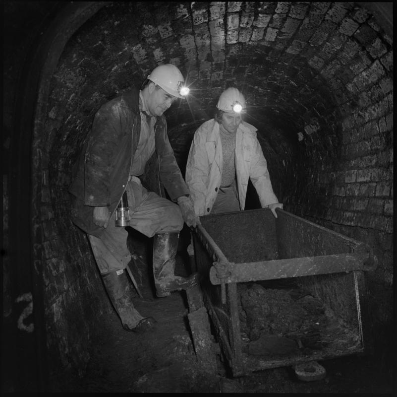 Black and white film negative showing two men pushing a dram, Big Pit Colliery.  'Big Pit Blaenavon' is transcribed from original negative bag.  Appears to be identical to 2009.3/2999.
