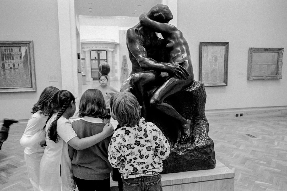 In the National Museum some students from a school party find interest in Rodin's sculpture 'The Kiss'. Cardiff, Wales