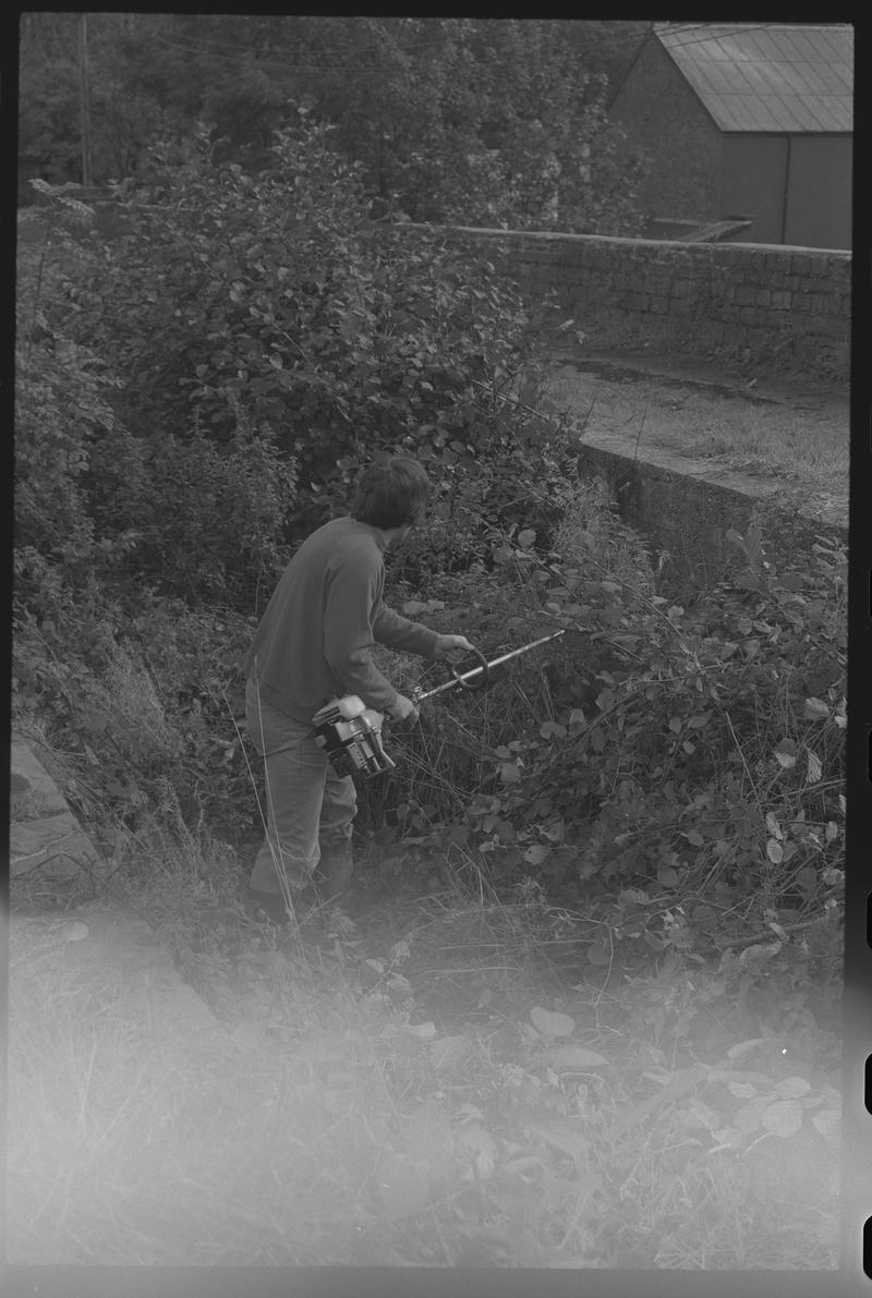 Man with strimmer, possibly a volunteer with Canal Society. Location unknown.