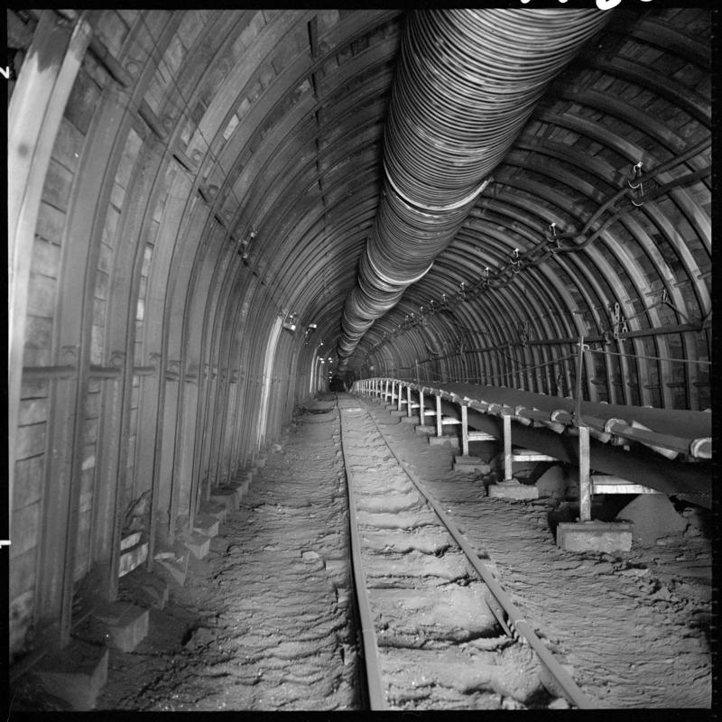 Black and white film negative showing a roadway with high speed conveyor, Blaengwrach Mine, 1 November 1979.  'Blaengwrach 1 Nov 1979' is transcribed from original negative bag.