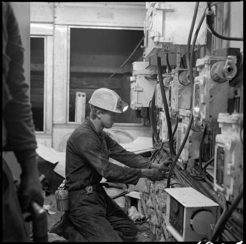 Black and white film negative showing man carrying out maintenance work, Lady Windsor Colliery.
