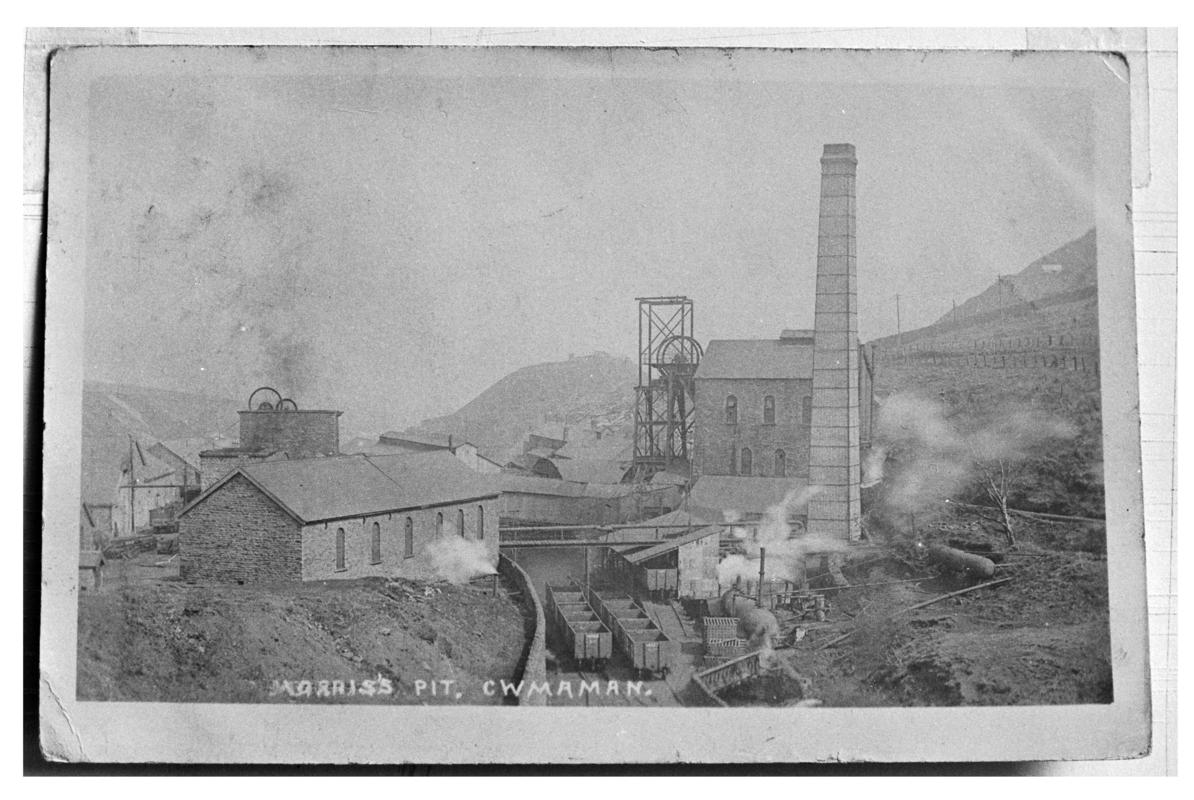 Black and white film negative of a photograph showing a surface view of Morris Pit, Cwmaman.  'Morris Pit Cwmaman' is transcribed from original negative bag.