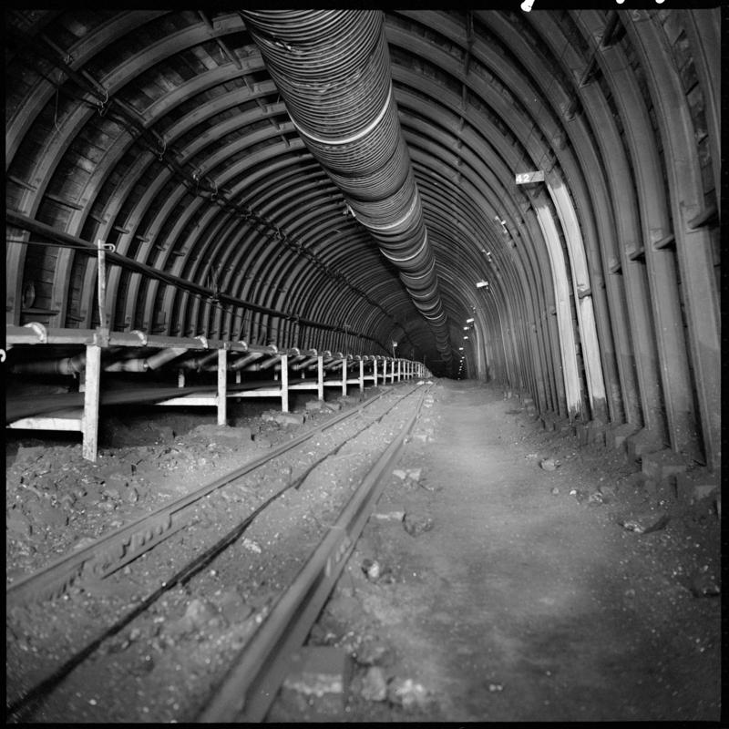Black and white film negative showing a roadway with high speed conveyor, Blaengwrach Mine, 1 November 1979.  'Blaengwrach 1 Nov 1979' is transcribed from original negative bag.