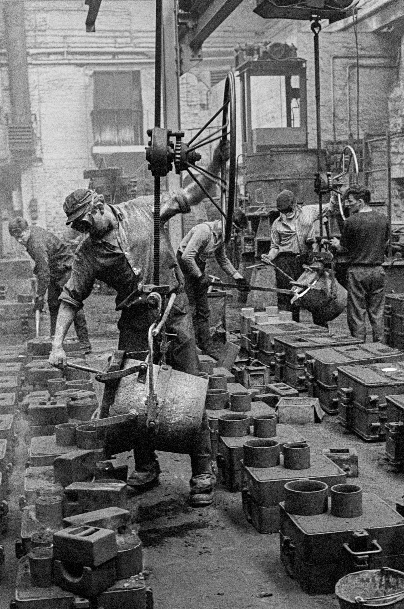Men casting in the Metal Box factory. Working in the steel industry is very dangerous work. Neath, Wales