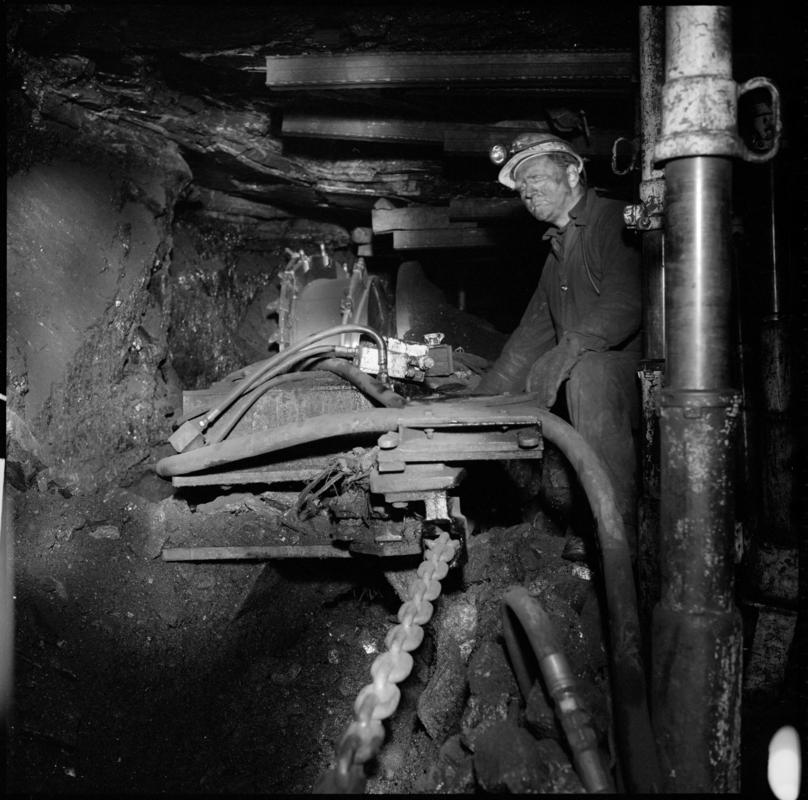 Black and white film negative showing an overman inspecting a shearer, Coegnant Colliery 1978-1979.  'Coegnant 1978-9' is transcribed from original negative bag.