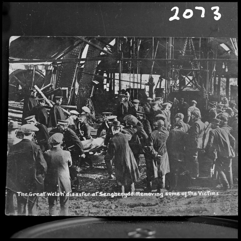 Black and white film negative of a photograph showing the scene at Universal Colliery, Senghenydd after the explosion of 14 October 1913.  Caption on photograph reads 'the Great Welsh disaster at Senghenydd.  Removing some of the victims'.