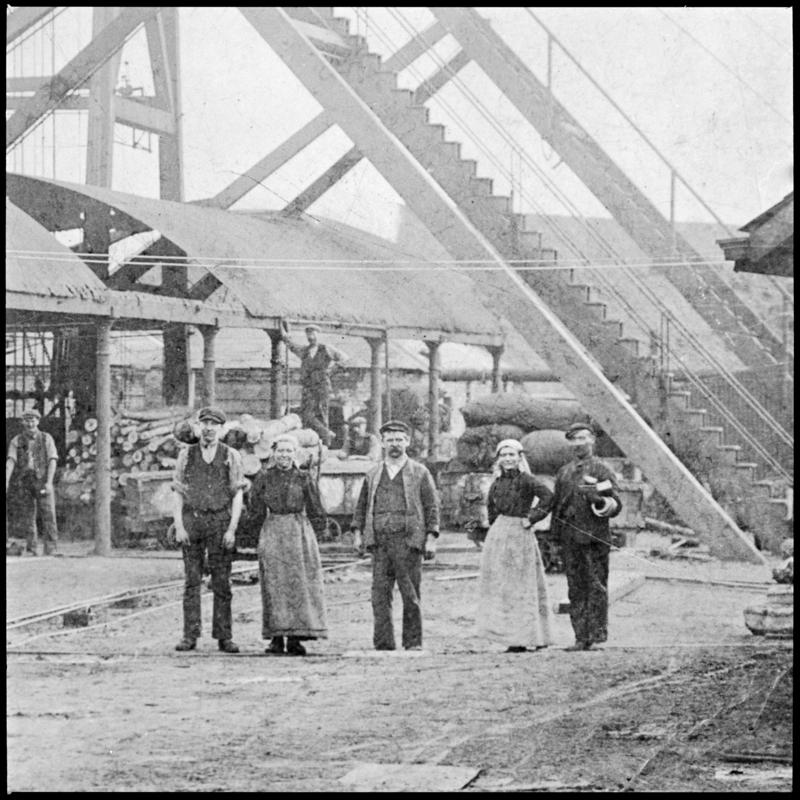 Black and white film negative of a photograph showing men and women near pit top, Whitworth Colliery.  'Whitworth' is transcribed from original negative bag.