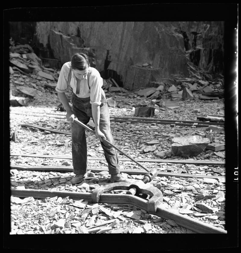 Quarryman straightening a section of rail, using a 'Jim Cro', Dinorwig Quarry, early 1960s.