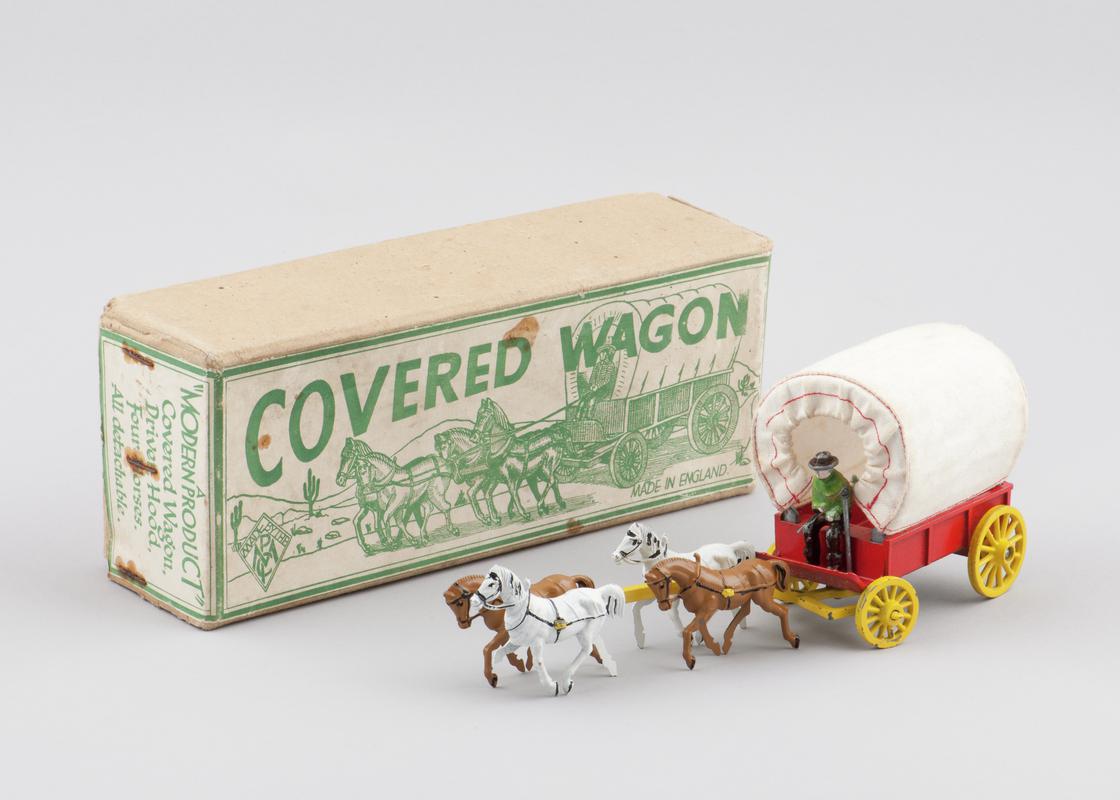 Red, cloth covered wagon with yellow wheels, pulled by four detachable horses. Detachable driver and whip (2001.52/1) with original box (2001.52/2).