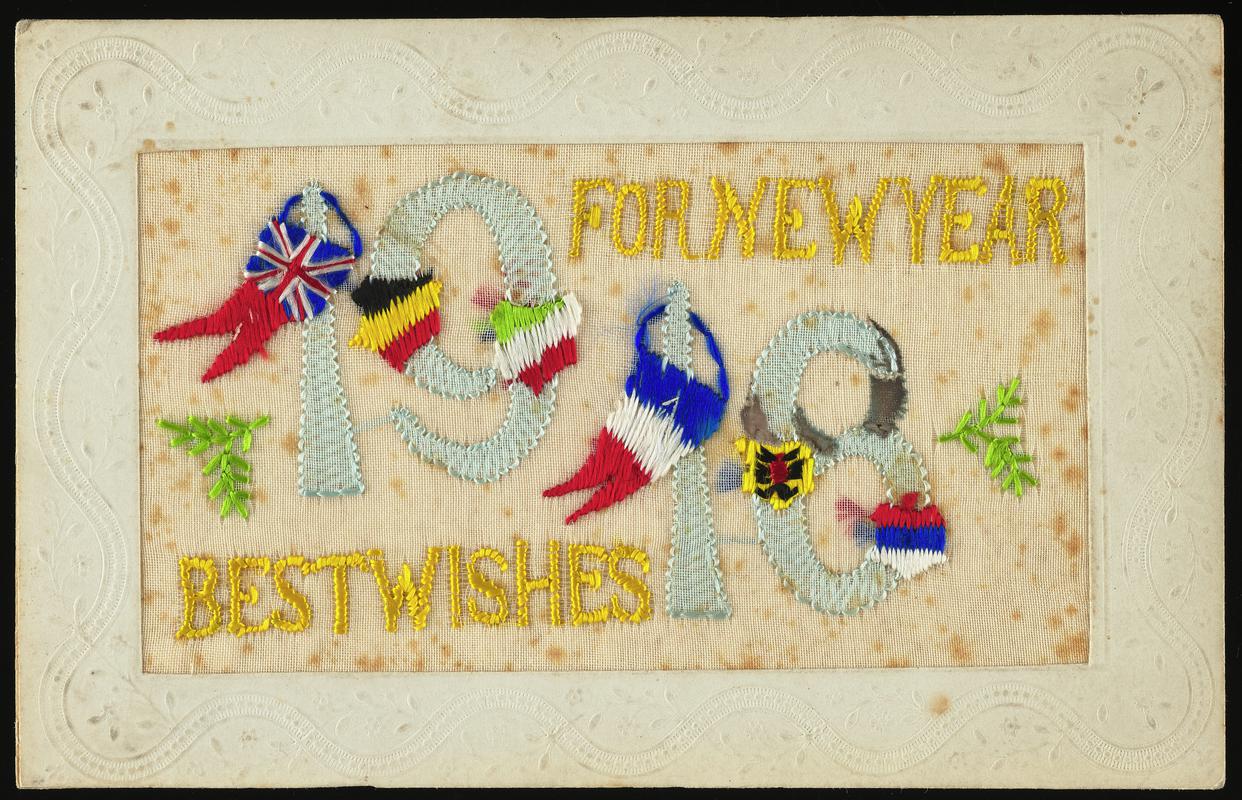 Embroidered postcard inscribed 'FOR NEW YEAR 1918 BEST WISHES'. Handwritten message on back. Sent to Miss Evelyn Hussey, sister of Corporal Hector Hussey of the Royal Welch Fusiliers, during the First World War.