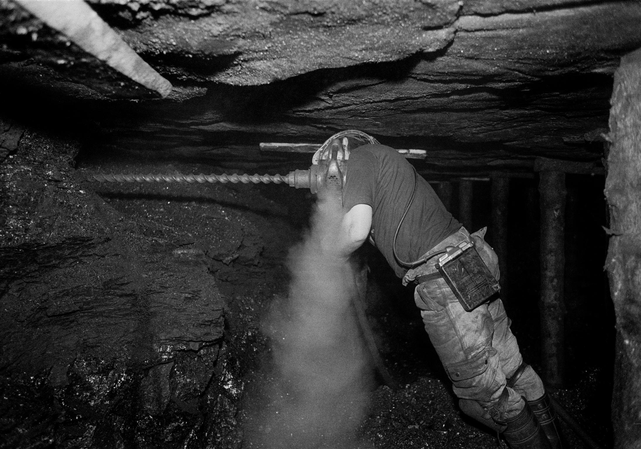 Black mountain coal. Miner drilling plug hole for blasting. Neath Valley, Wales