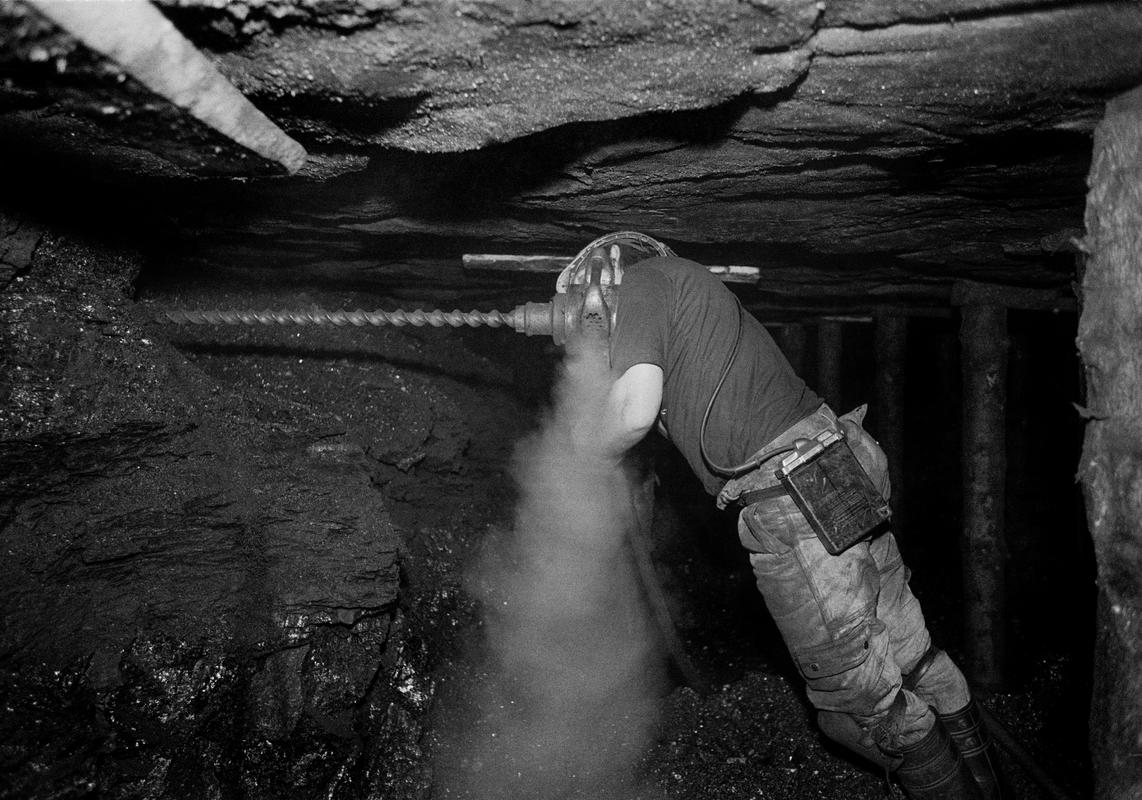 GB. WALES. Neath Valley. Black mountain coal. Miner drilling plug hole for blasting. 1993