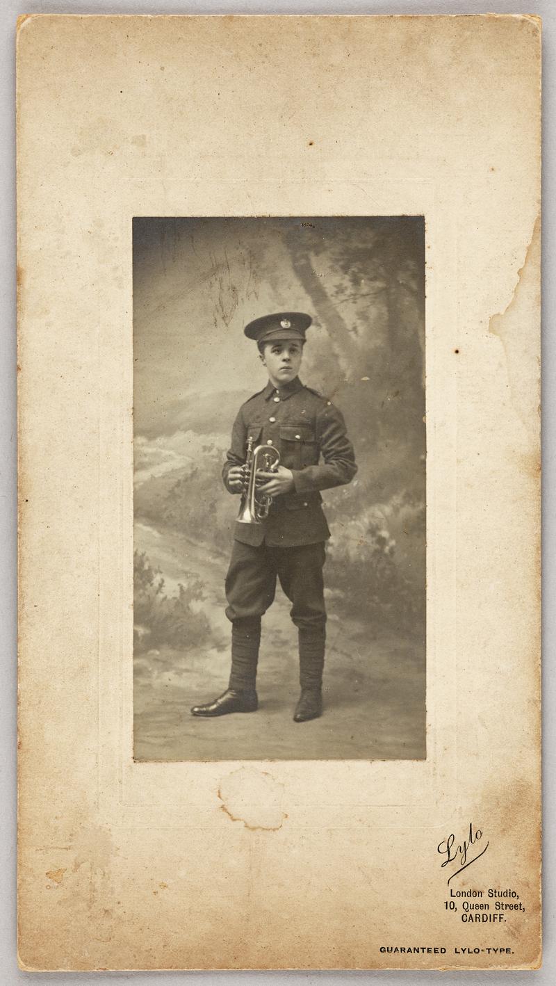 Young C.H. Watkins in uniform with a trumpet. Print mounted on card with photographers details printed bottom right of mount.