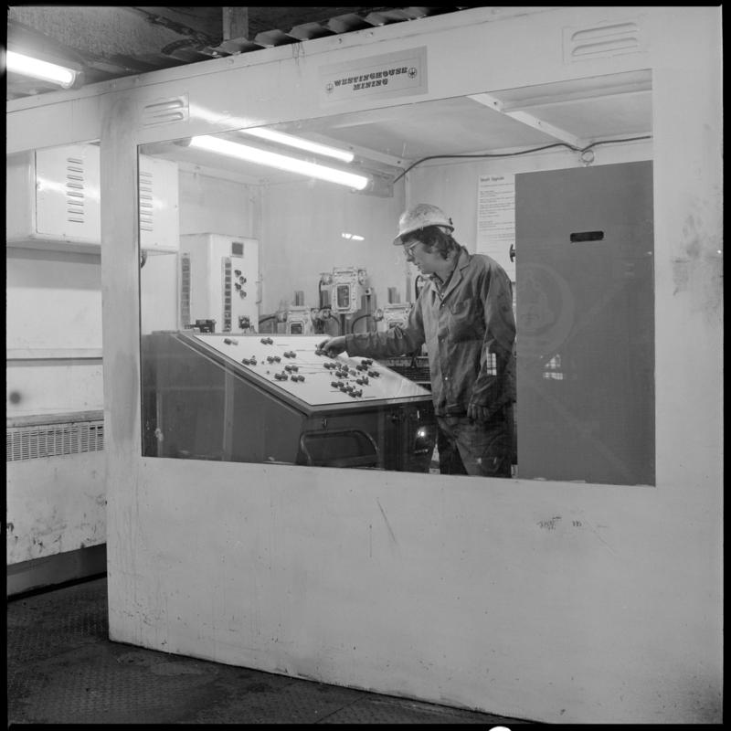 Black and white film negative showing man operating controls, Lady Windsor Colliery.