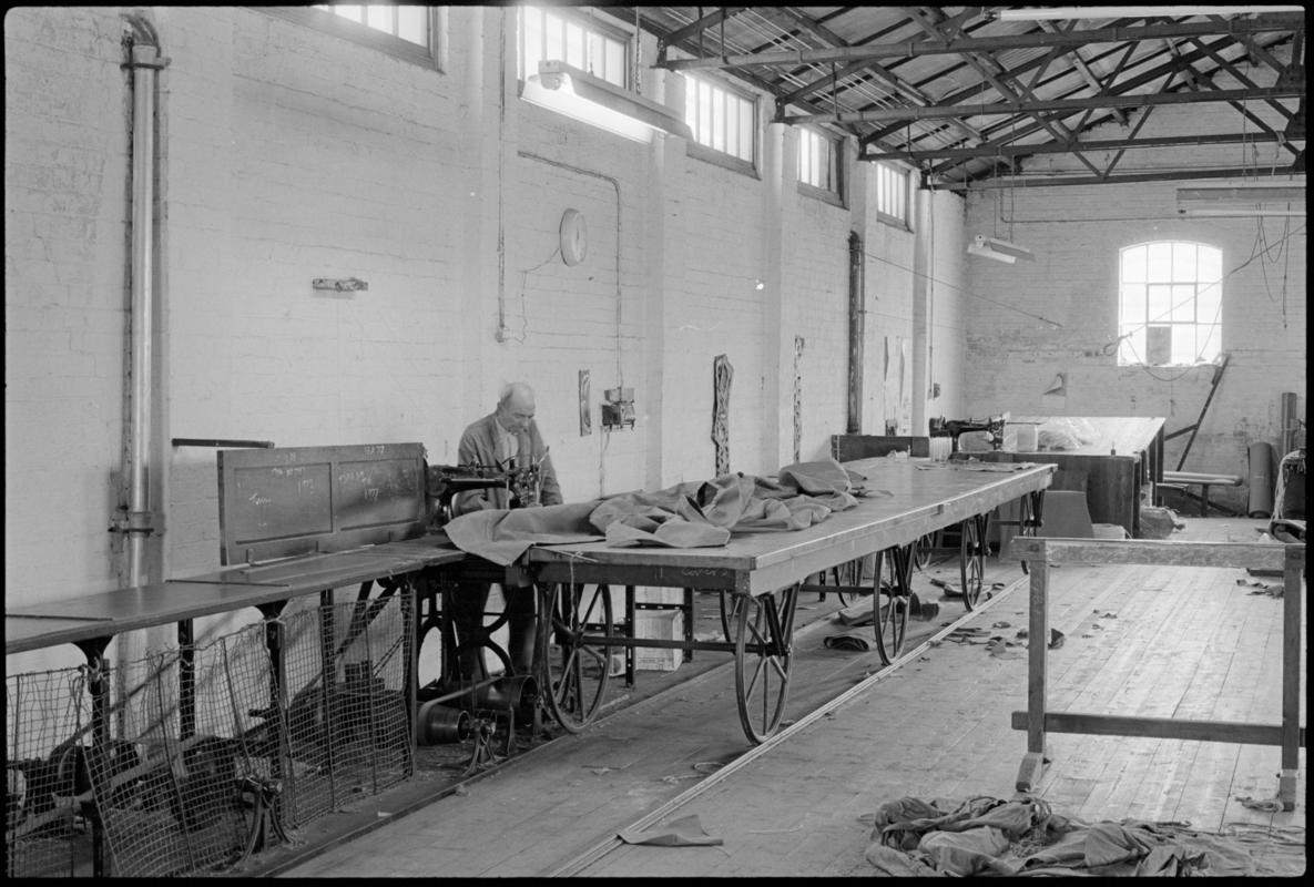 Mr Hopwood using one of the sailmaking tables with wheels that run on a track at Jenkin Jones and Son sailmakers, 12 Hurman Street, Cardiff Docks.